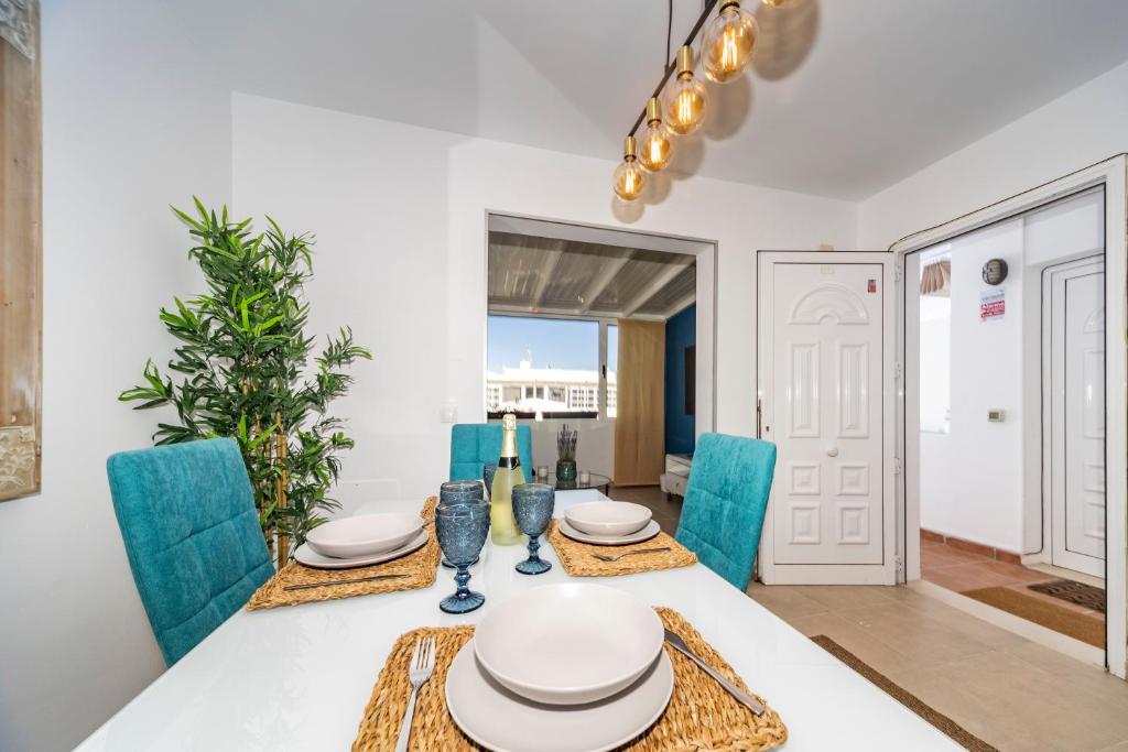 uma sala de jantar com uma mesa e cadeiras azuis em Luxury Apartment Chalana em Playa Honda