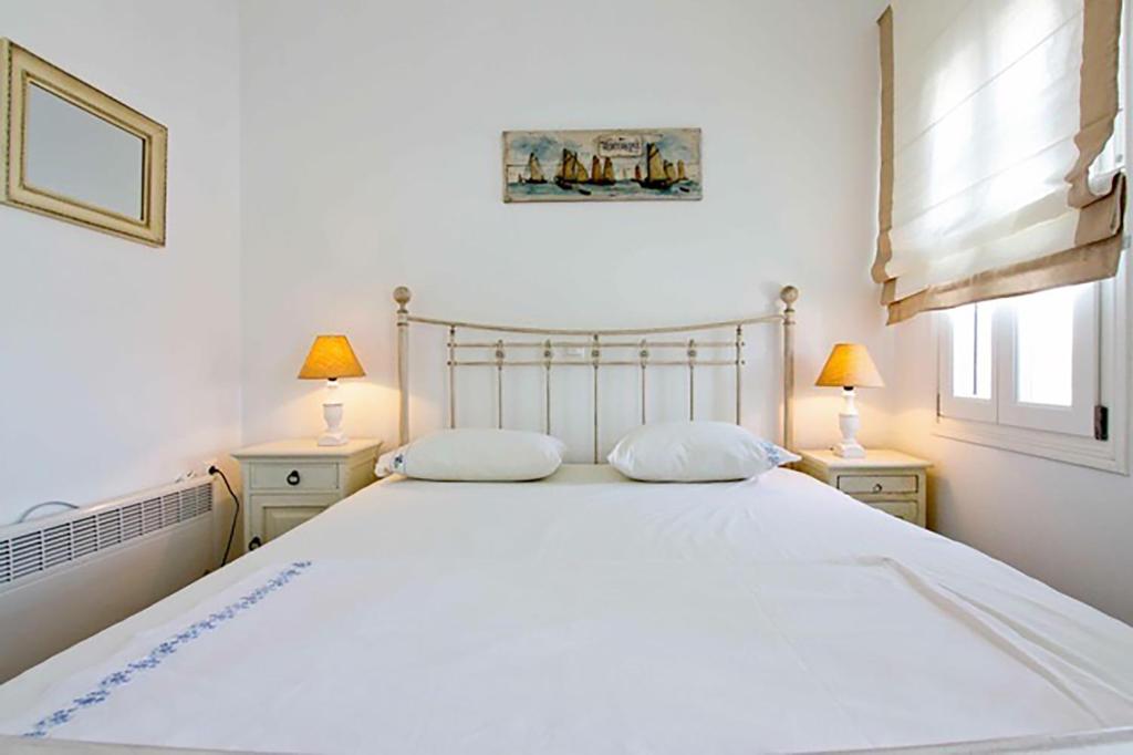 1 dormitorio con 1 cama blanca grande y 2 lámparas en Dolce Vita Waterfront Villa, Logaras, Paros, en Kampos