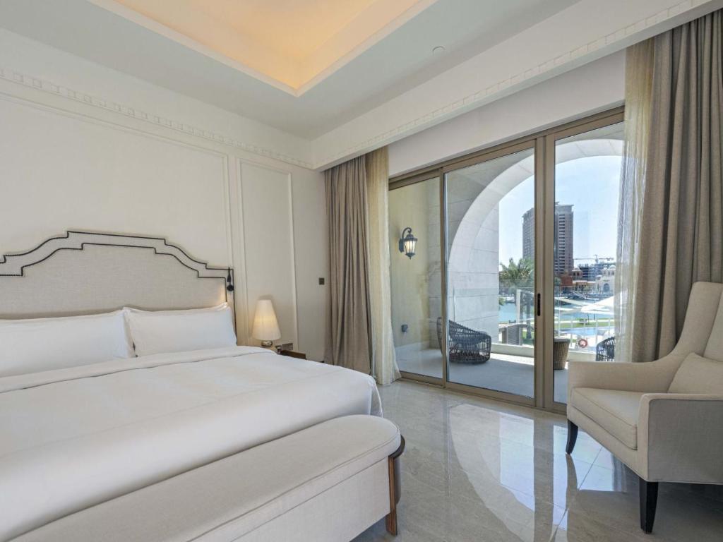 una camera con un letto e una sedia e una finestra di Town house residency 4 a Doha