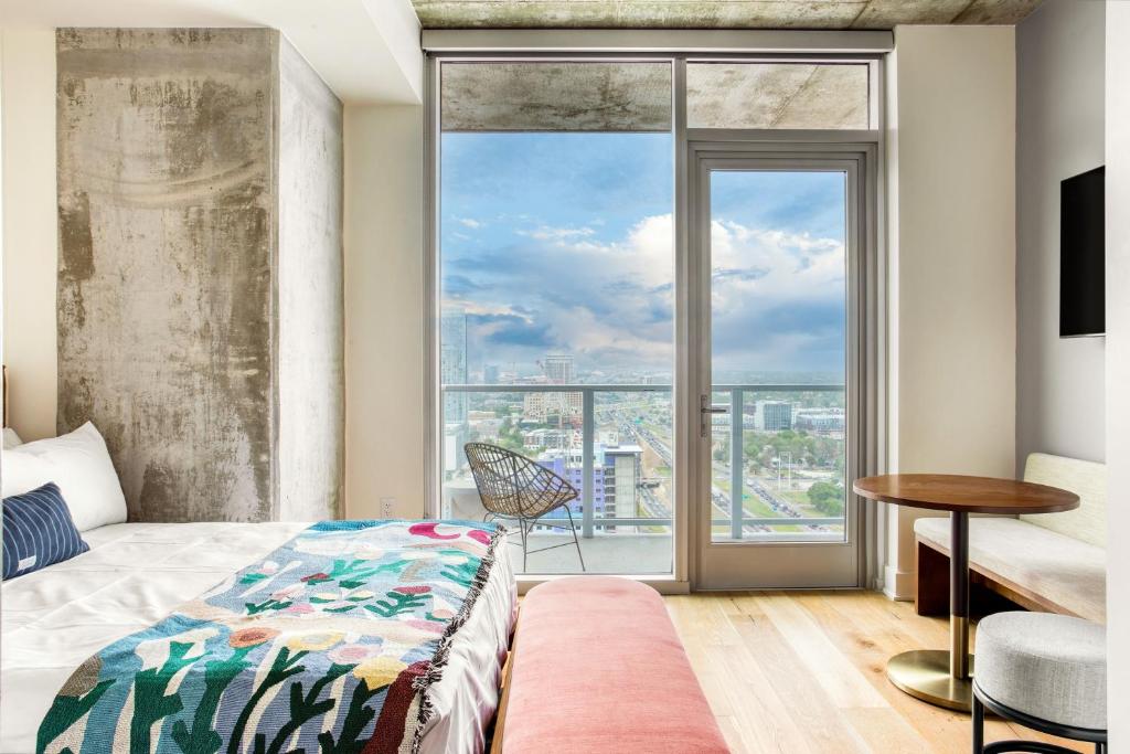 ein Schlafzimmer mit einem Bett und einem großen Fenster in der Unterkunft Carousel by AvantStay Brand New Condo in Austin w Amazing Amenities in Austin