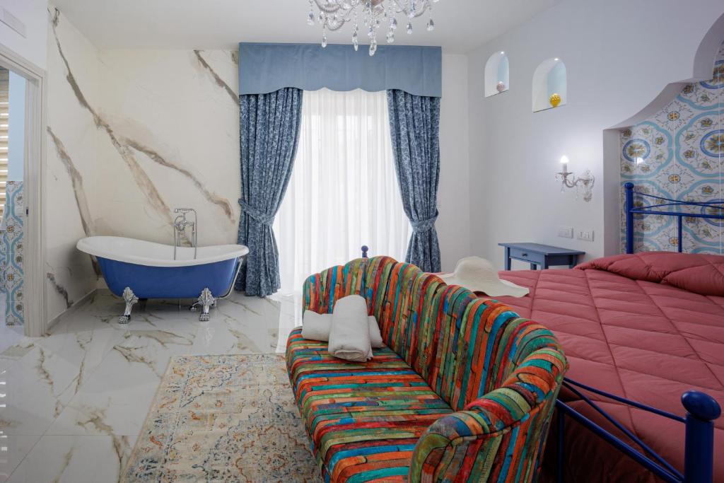 a bedroom with a bed and a tub and a couch at REDDIMUS Guest House in Naples