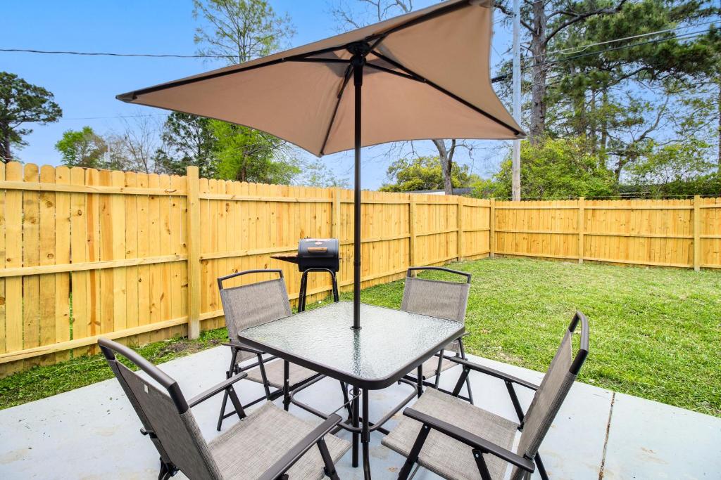 een tafel en stoelen met een parasol in de achtertuin bij Inviting Savannah Home with Yard 3 Mi to Downtown! in Savannah