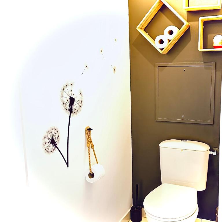 a bathroom with a toilet with a dandelion on the wall at Beautiful apartment * parking* Disneyland 10 min in Montévrain