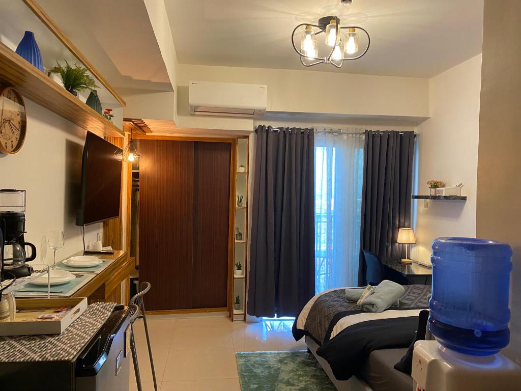 1 dormitorio con 1 cama y TV en una habitación en Cozy and Convenient studio unit @ Inspiria condominium, en Davao City