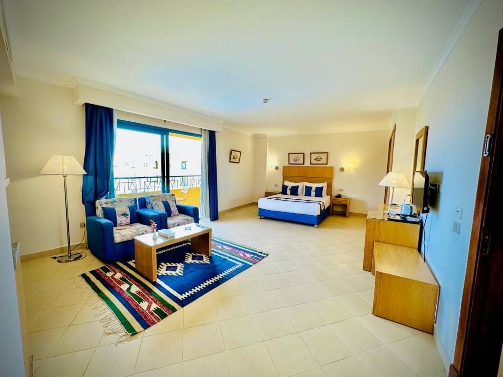 a living room with a blue couch and a bed at Eagles Downtown Resort in Hurghada