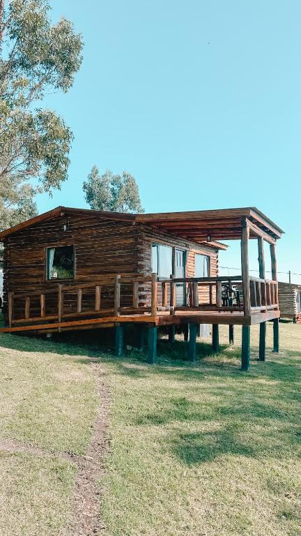 a large log cabin with a porch and a porch at Piedra que late in Tandil