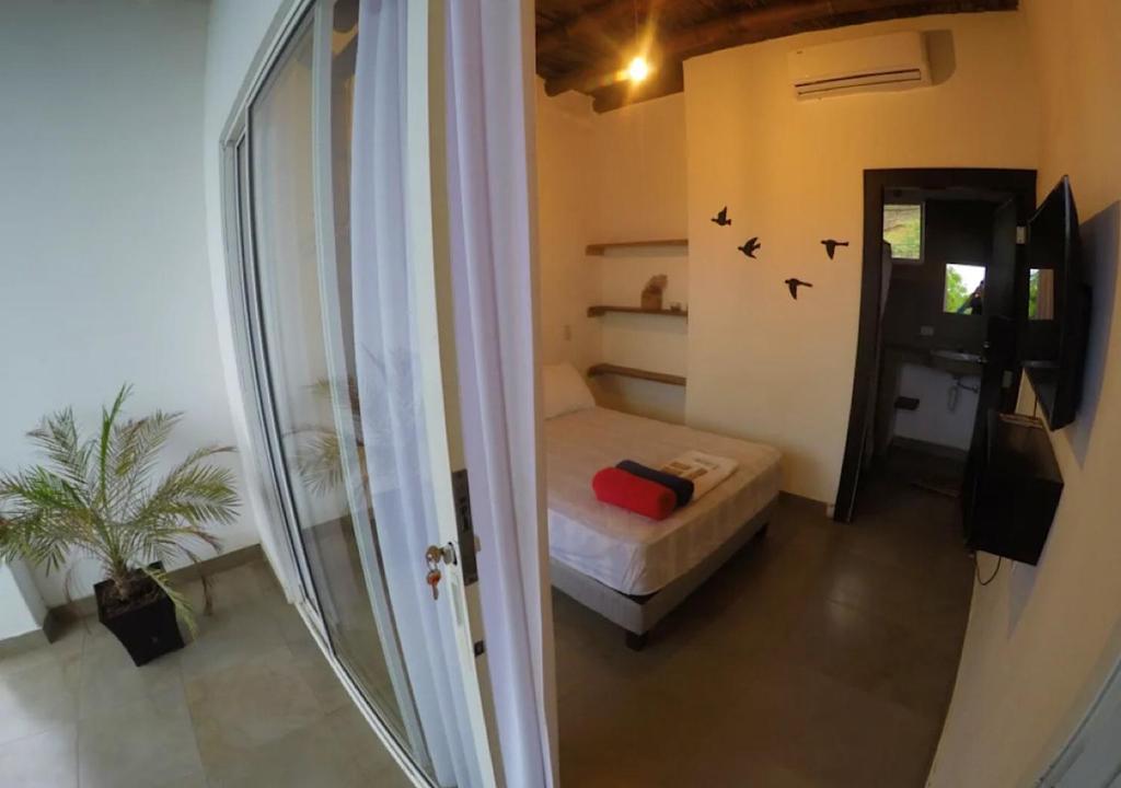 een kleine kamer met een bed en een raam bij KIWi MONTAÑITA in Montañita