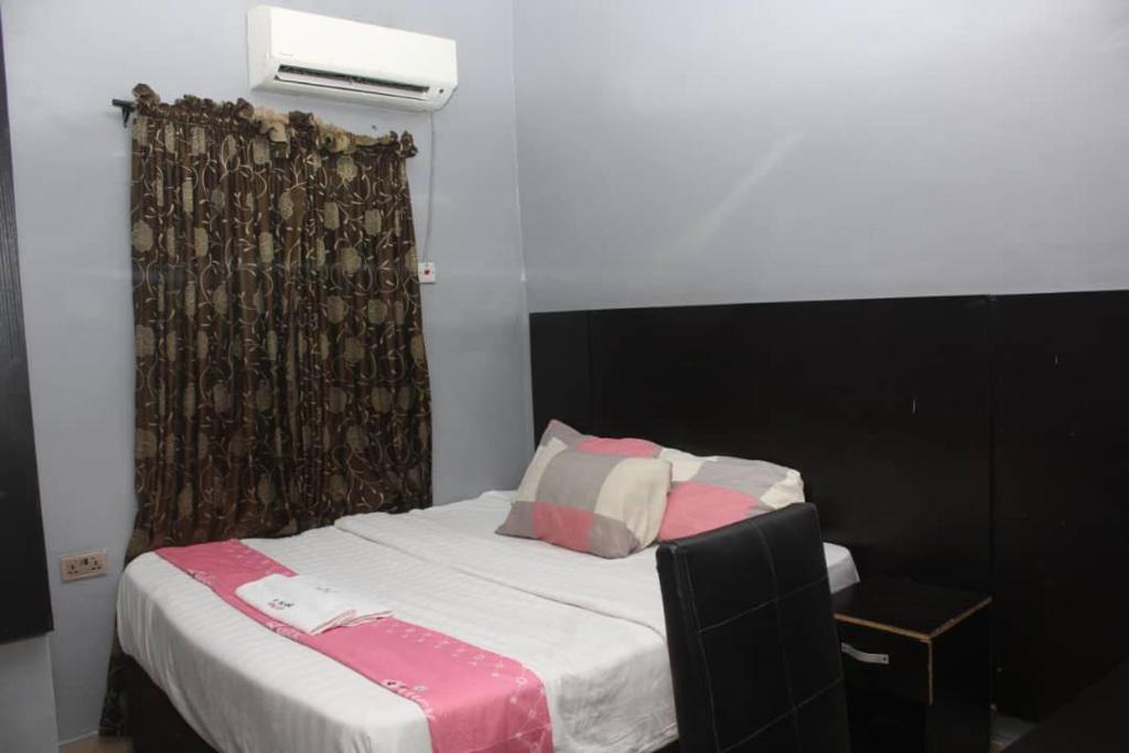 萊基的住宿－D'Island hotel and club，一间卧室配有一张带黑色床头板的床和窗户