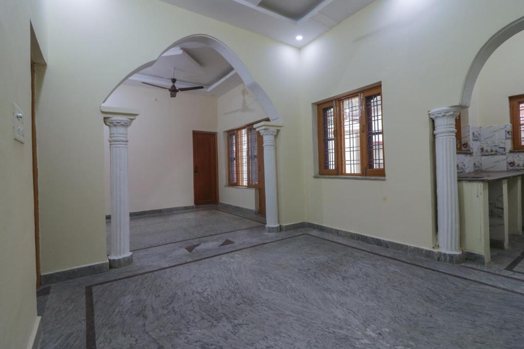 an empty room with white walls and windows at SPOT ON The Greenwoods Retreat in Jhājra