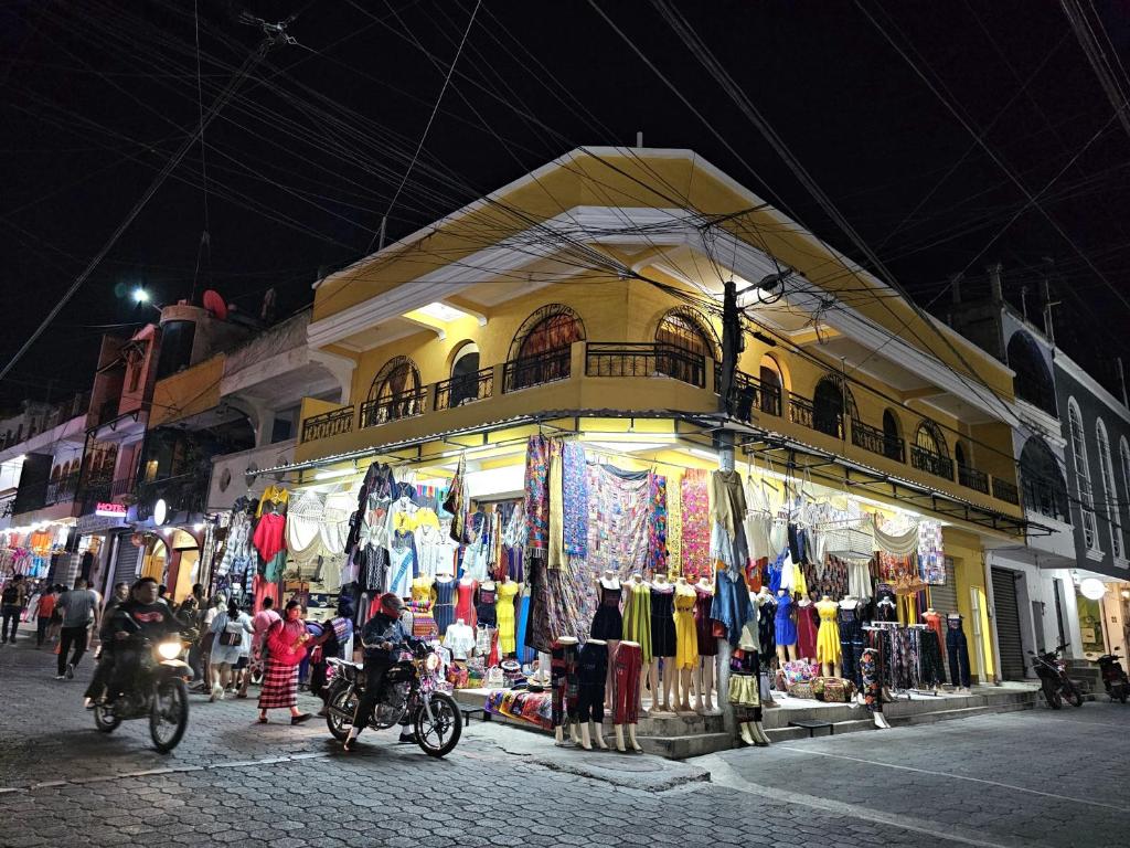 a store with people riding motorcycles in front of it at Hostal flor del lago in Panajachel