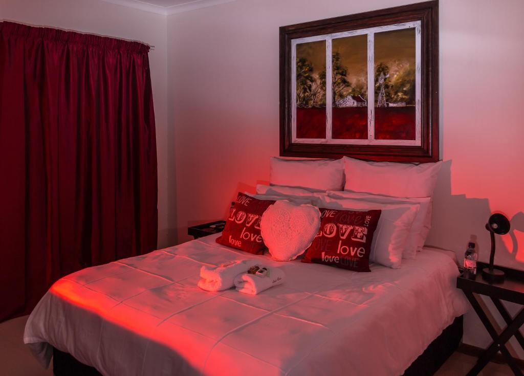 een slaapkamer met een bed met een hart en een raam bij Memra Guest House in Ladysmith