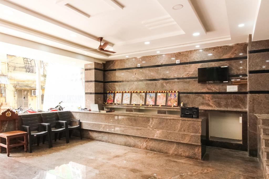 a bar in a restaurant with a stone wall at Collection O Sree Guru Lakshmi Residency in Tirupati