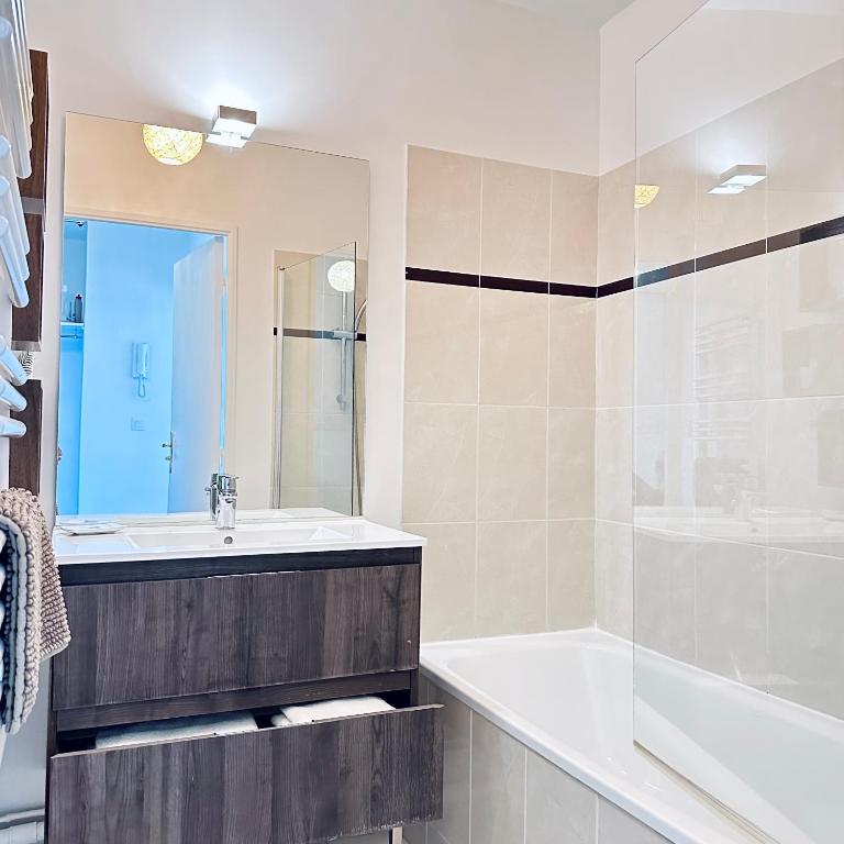 a bathroom with a sink and a tub and a shower at Beautiful apartment * parking* Disneyland 10 min in Montévrain