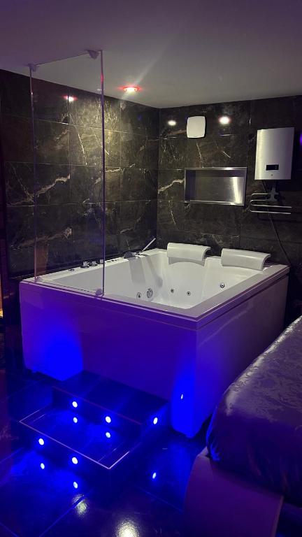 eine große Badewanne mit blauen Lichtern im Bad in der Unterkunft 1001 nuits F in Fénay