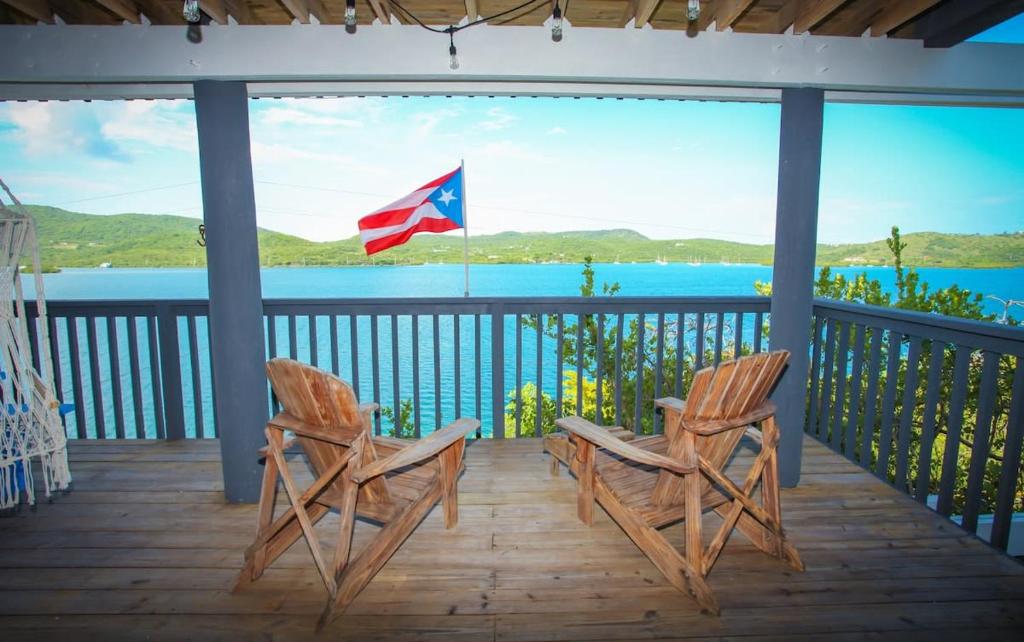 two chairs on a porch with a view of the water at Ocean Front Villa 2 in Culebra
