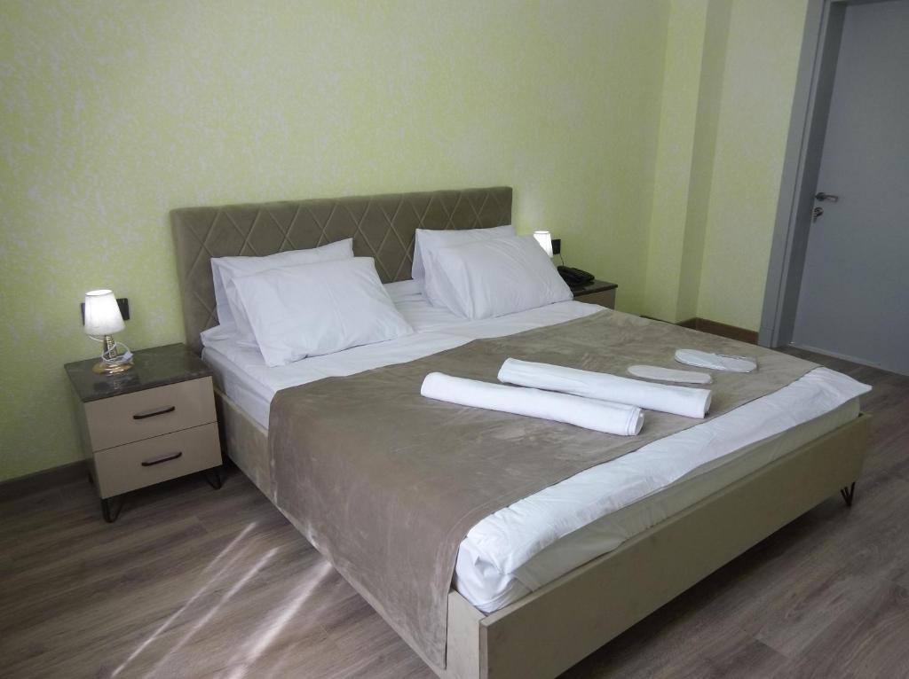 a large bed with two white towels on it at Avrasya Hotel in Baku