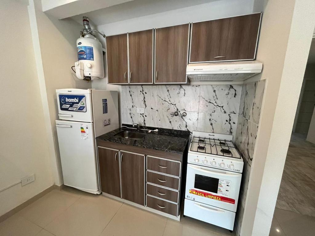 a kitchen with a white stove and a refrigerator at Departamento nuevo en San Bernardo in San Bernardo