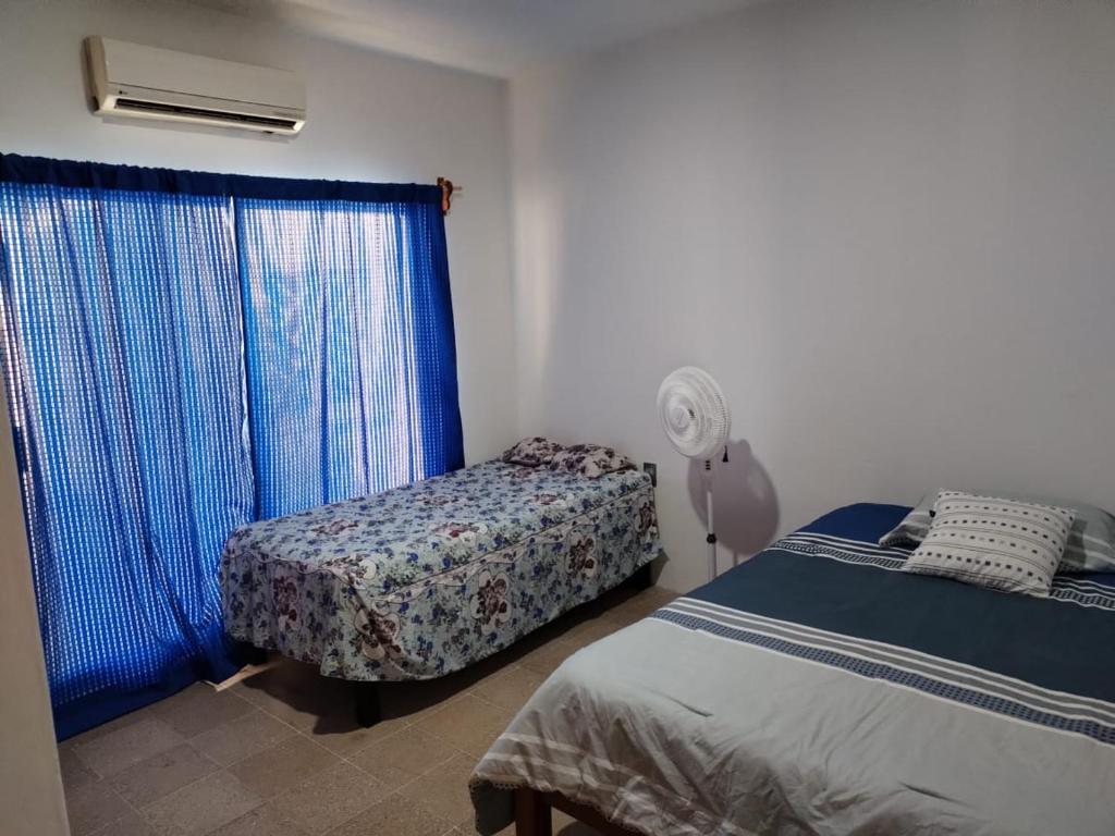 1 dormitorio con 2 camas y ventana en Casa LUNA ven y disfruta, en Veracruz
