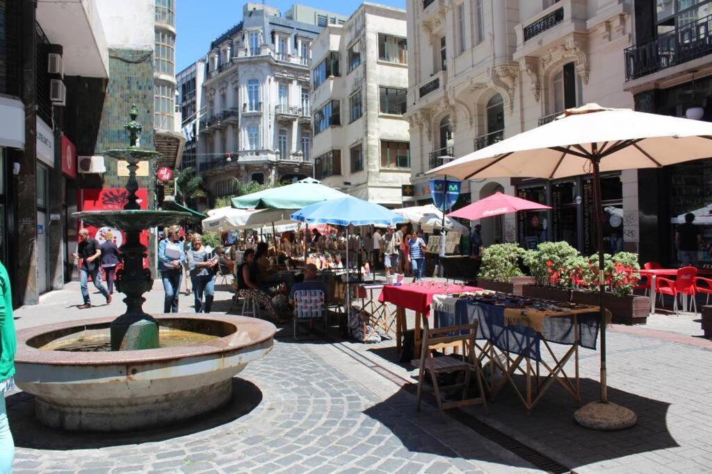 una calle de la ciudad con una fuente, mesas y sombrillas en Moderno y Minimalista en Ciudad Vieja Montevideo, en Montevideo