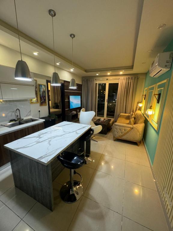a kitchen and living room with a sink and a counter at The Designer Den opposite to Centaurus mall in Islamabad
