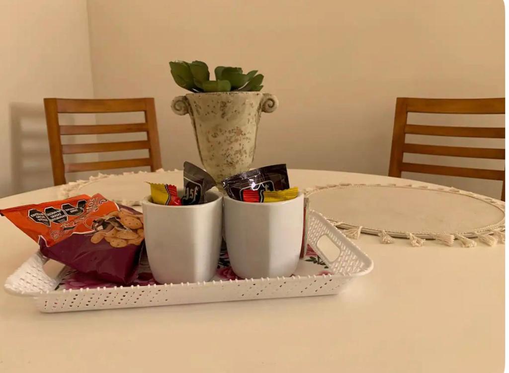 - un plateau avec deux tasses sur une table et un vase dans l'établissement Apartamento Entero en Ezeiza/ Canning, à Canning