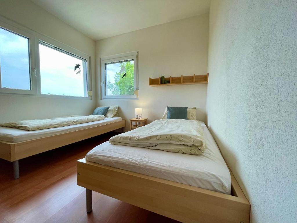 1 dormitorio con 2 camas y 2 ventanas en Belle Vue, en Cserszegtomaj
