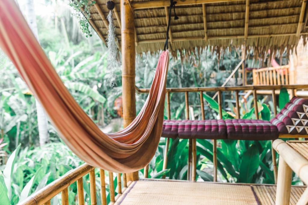 a hammock on a porch of a house at Bamboo Bay Island Resort in Srithanu