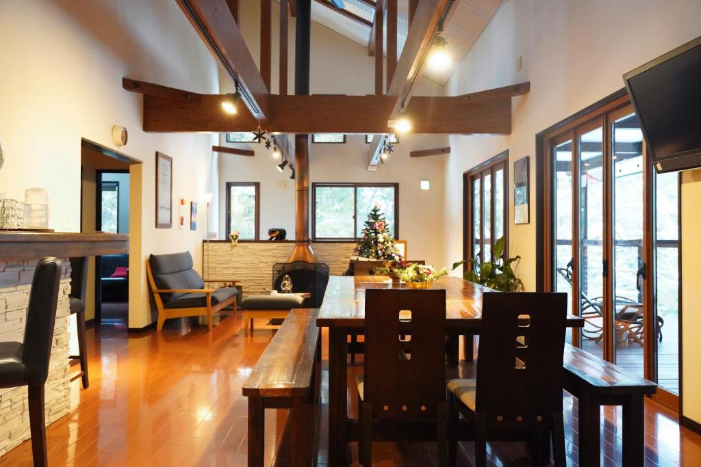 a dining room with a long wooden table and chairs at Bears Den Mountain Lodge in Hakuba