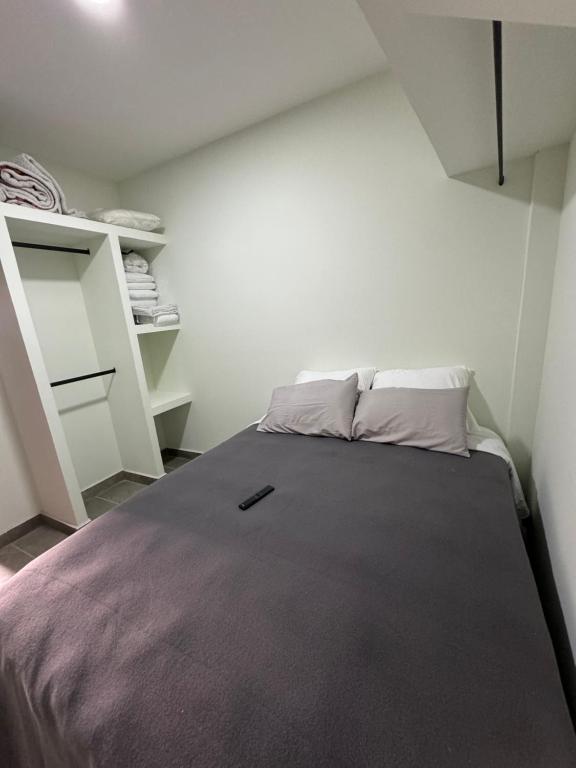 a small bedroom with a bed and shelves at Departamento PYO in Mexico City