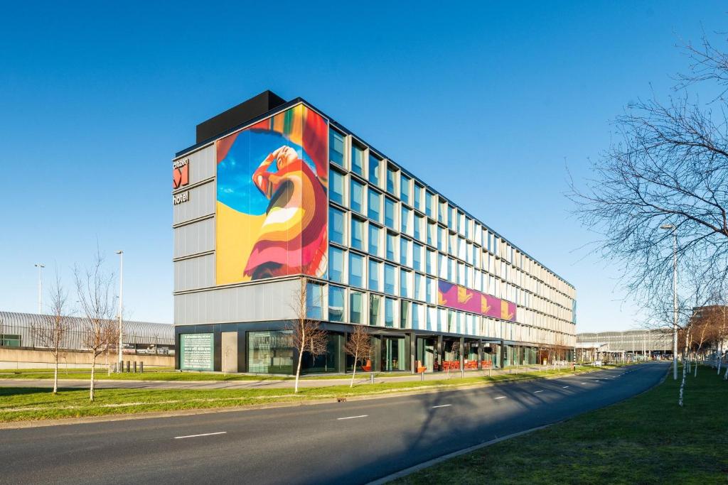 a building with a large painting of a dog on it at citizenM Schiphol Airport in Schiphol