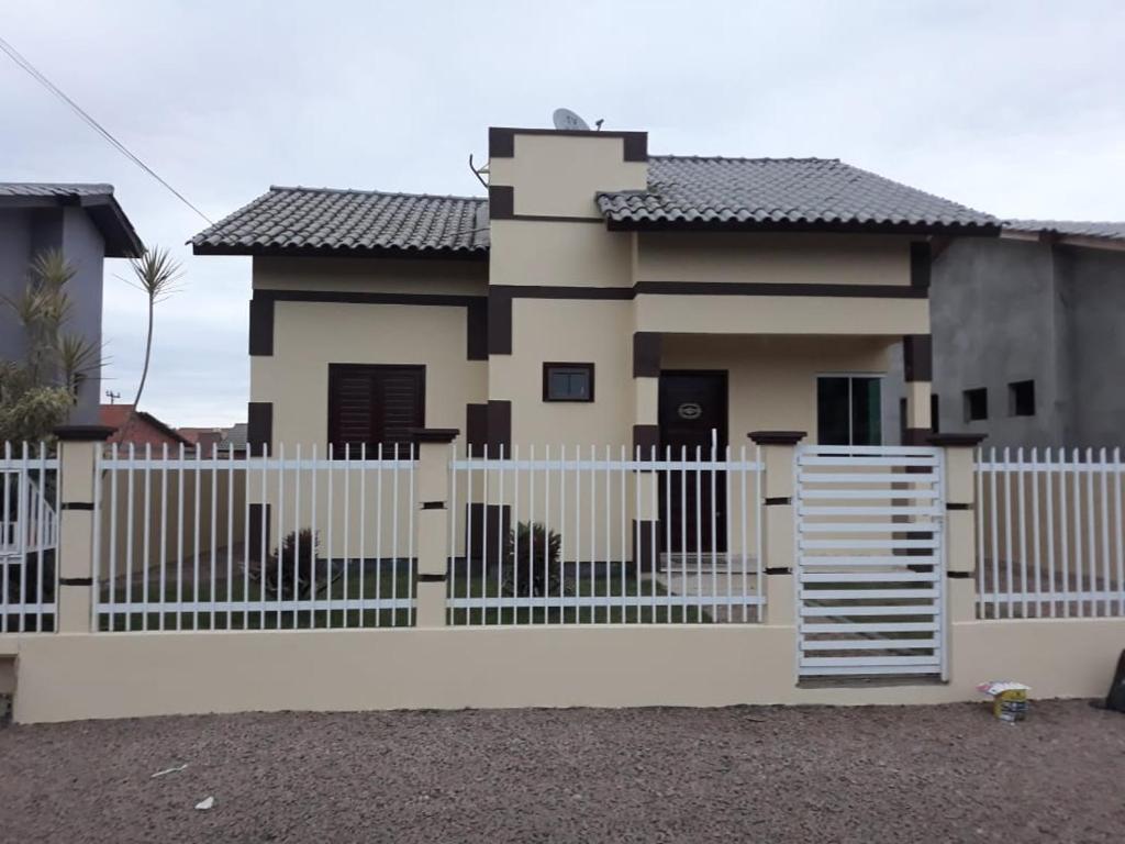 a white fence in front of a house at Casa Criciúma in Criciúma