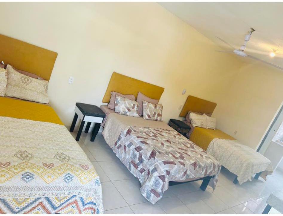sypialnia z 2 łóżkami, stołem i spódniczkami w obiekcie KID'S w mieście El Naranjo