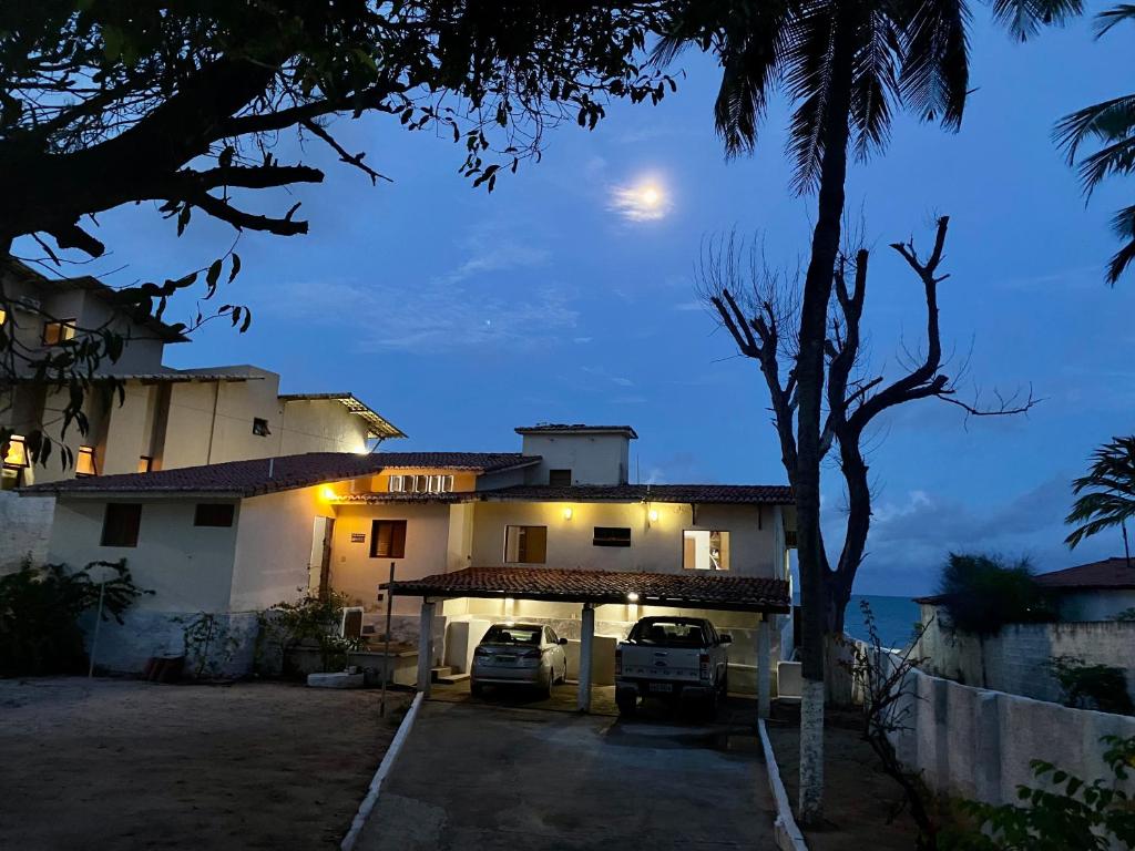 uma casa com carros estacionados em frente a ela à noite em Bela vista com pé na areia em Ceará-Mirim
