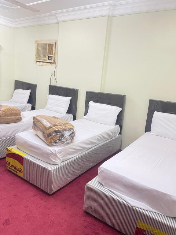 two twin beds in a room with a box at غرفة وحمام مكة العزيزية قريب الحرم in Al ‘Azīzīyah