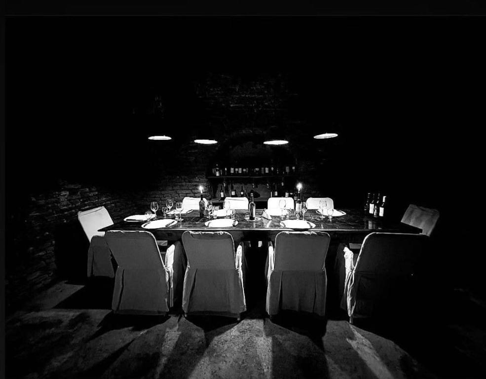 a black and white photo of a table with chairs at el oráculo. cava de vinos. unión club in El Sauce