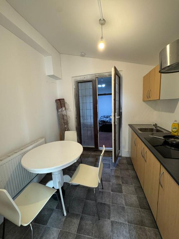 a kitchen with a white table and chairs in a room at Crete home in Oldham