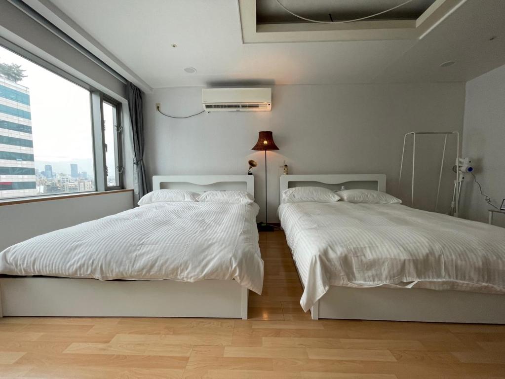 1 dormitorio con 2 camas y ventana grande en Hongdae Guesthouse3 1min from Hongik Uni station Exit #1, en Seúl