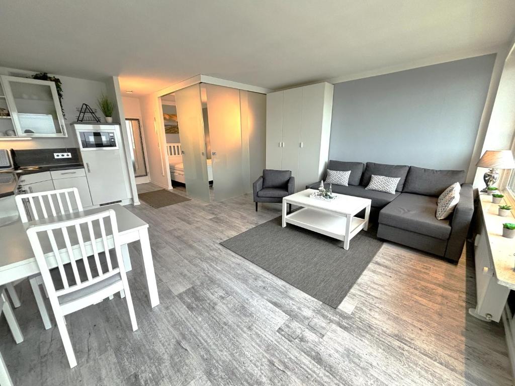 ein Wohnzimmer mit einem Sofa und einem Tisch in der Unterkunft Ferienpark Sierksdorf App 779 - Strandlage in Sierksdorf