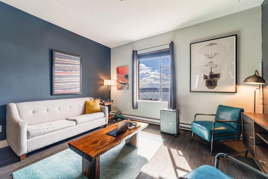 a living room with a couch and a table and chairs at Oxford Apartment by At Mine Hospitality in Seattle