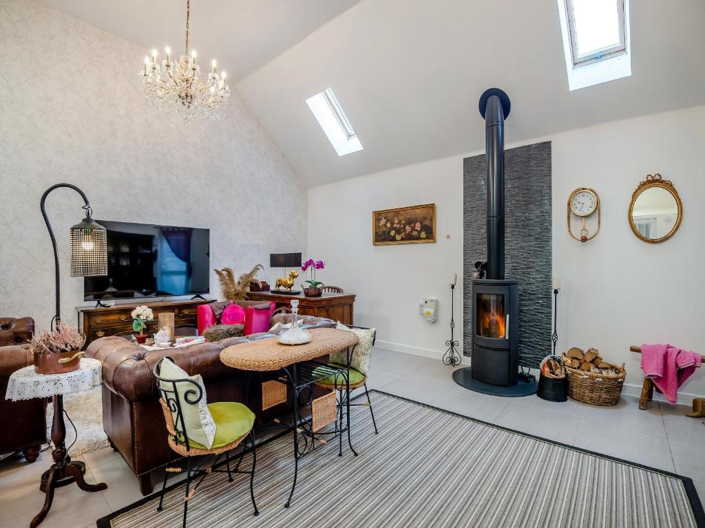 uma sala de estar com um sofá e um fogão a lenha em Dukes House em Corsham