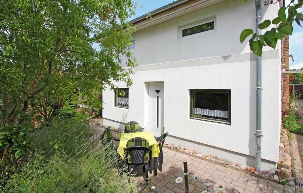 une moto jaune garée devant une maison blanche dans l'établissement Nice Home In Ribnitz-damgarten With Kitchen, à Ribnitz-Damgarten