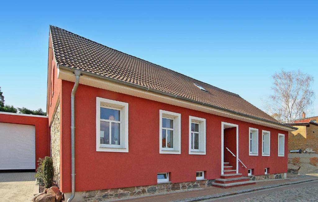 une maison rouge avec un toit rouge dans l'établissement Lovely Apartment In Rheinsberg Ot Flecken With Kitchen, à Flecken Zechlin