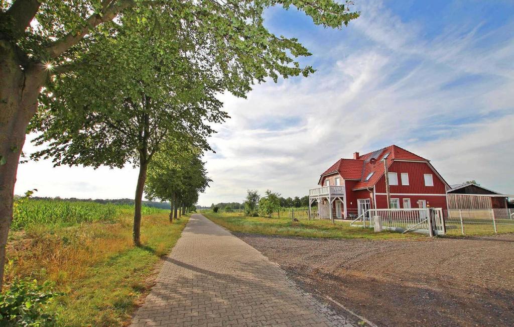 a red barn and a road next to a house at Nice Apartment In Userin Ot Gro Quassow With Wifi in Groß Quassow