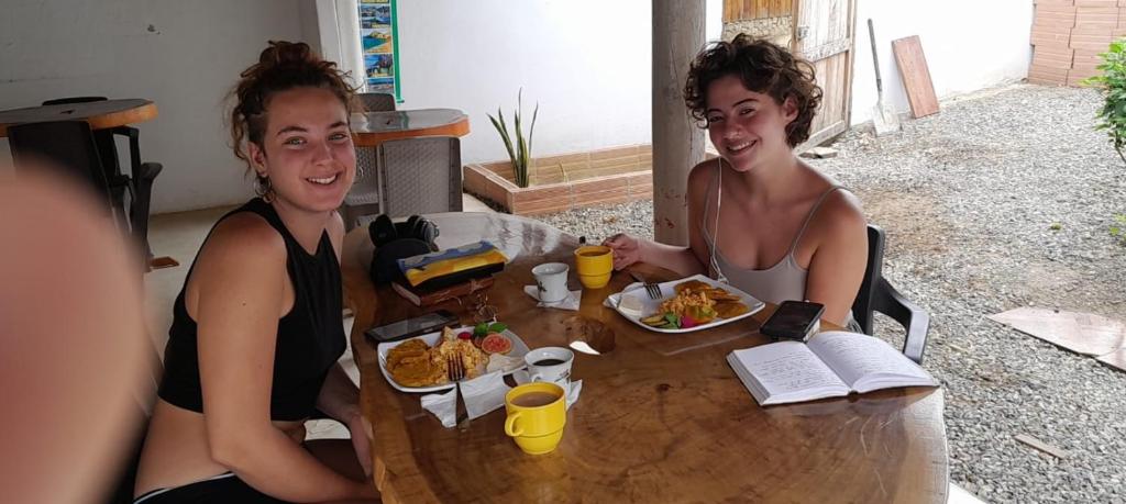 dos mujeres sentadas en una mesa comiendo comida en Hostal Paloma Café, en Palomino