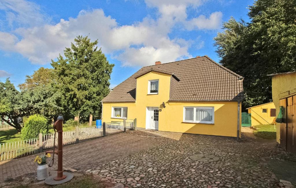 una casa amarilla con una valla delante de ella en 1 Bedroom Gorgeous Apartment In Patzig Auf Rgen, en Patzig