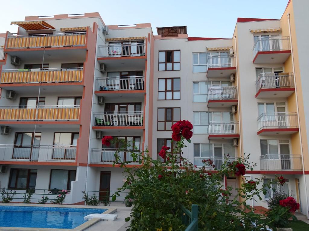 ein Apartmenthaus mit einem Pool davor in der Unterkunft Apartments in Lotos Complex in Kranewo