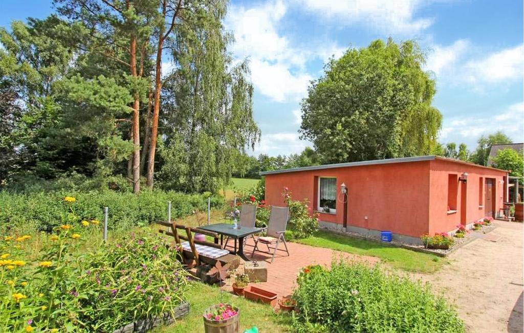 uma pequena casa vermelha com uma mesa de piquenique num jardim em 1 Bedroom Stunning Home In Waren mritz em Kölpinsee