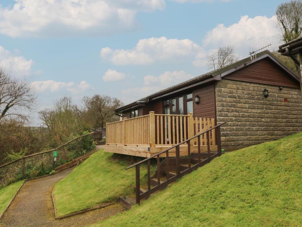 a house on a hill with a deck at Chalet Log Cabin C11 in Ilfracombe