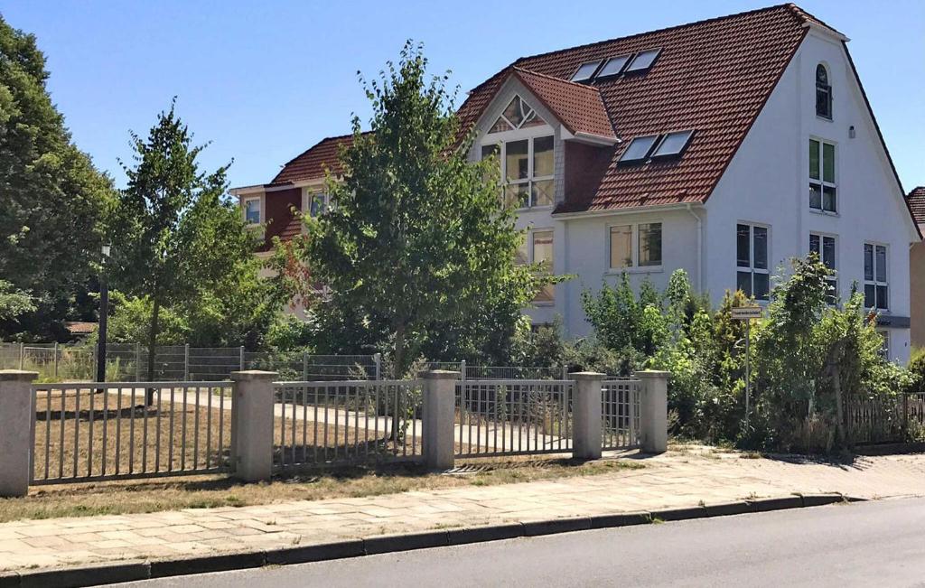 ein weißes Haus mit einem Zaun davor in der Unterkunft Amazing Apartment In Neubrandenburg With Wifi in Neubrandenburg