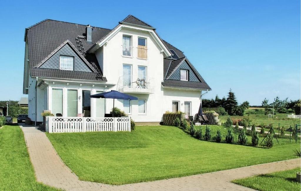 a white house with a white fence in the yard at Beautiful Apartment In Neppermin-usedom With Wifi in Neppermin
